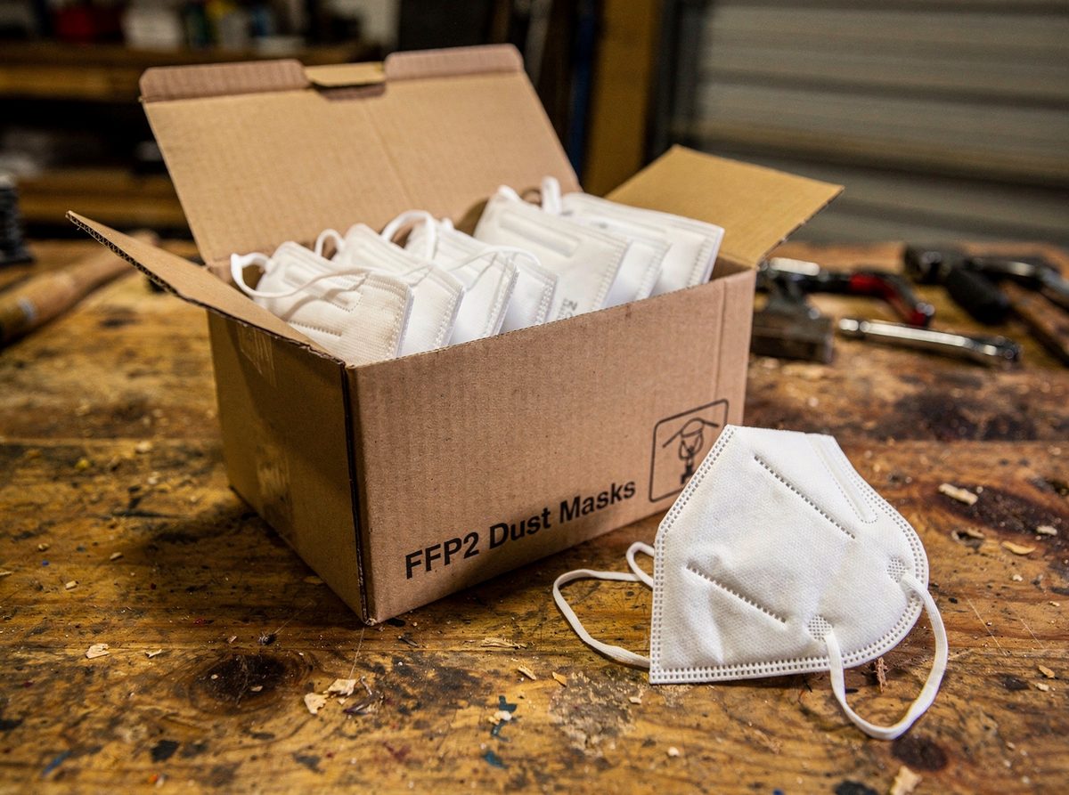 Open box of FFP2 dust masks with one mask resting beside it
